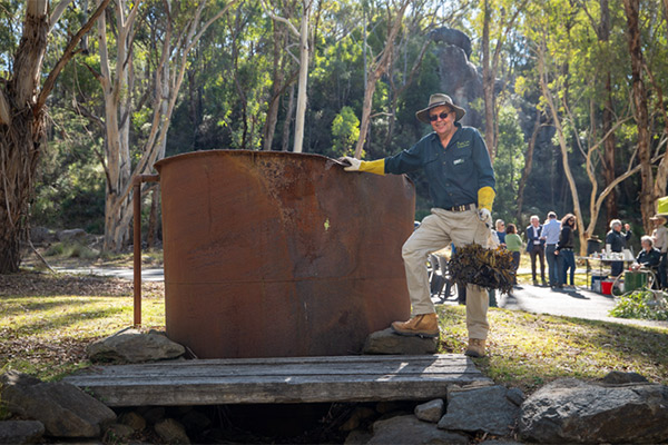 A volunteer proudly displays part of the old eucalyptus distillery.