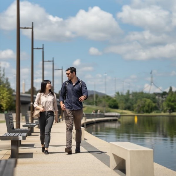 2 people walking on the shores of Lake Burley Griffin at Henry Rolland Park